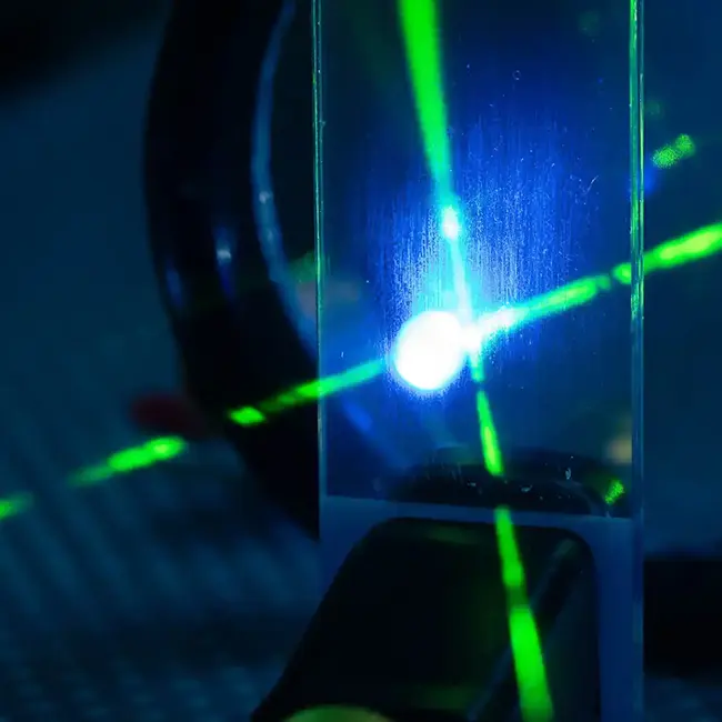 Laserstrahlen kreuzen sich vor dunklem Grund